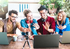 Amigos sentados à mesa, 2 homens e 2 mulheres acenando para um notebbok Acer Aspire 5 a sua frente.